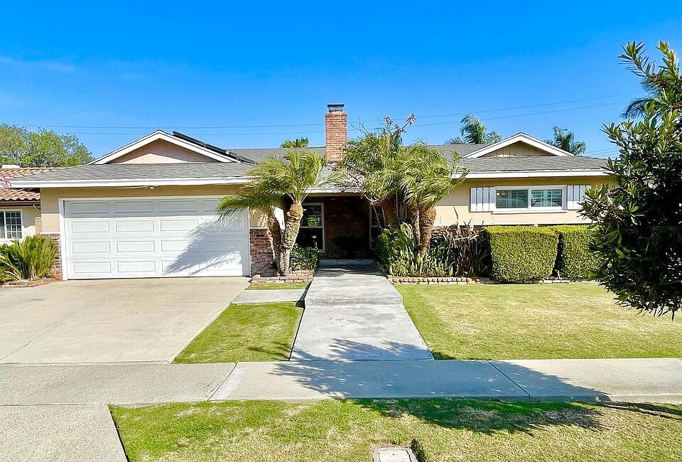 Wide front elevation reprise of 16622 Tiber Ln showing the single-story ranch, brick masonry, central chimney, attached two-car garage, and mature palms as the tour closes